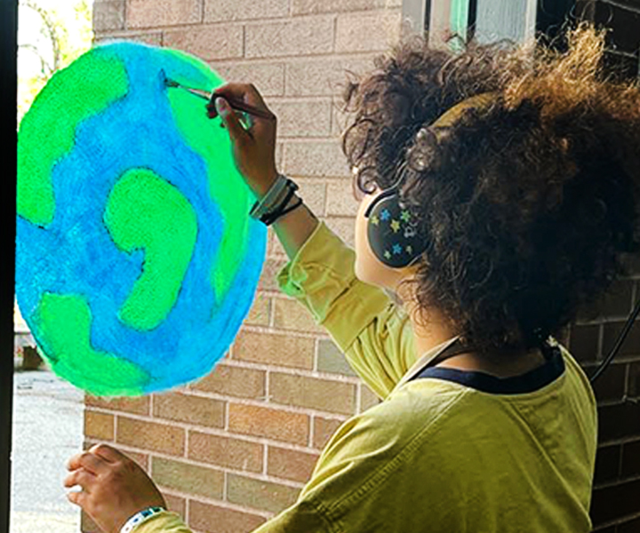 Student painting a window